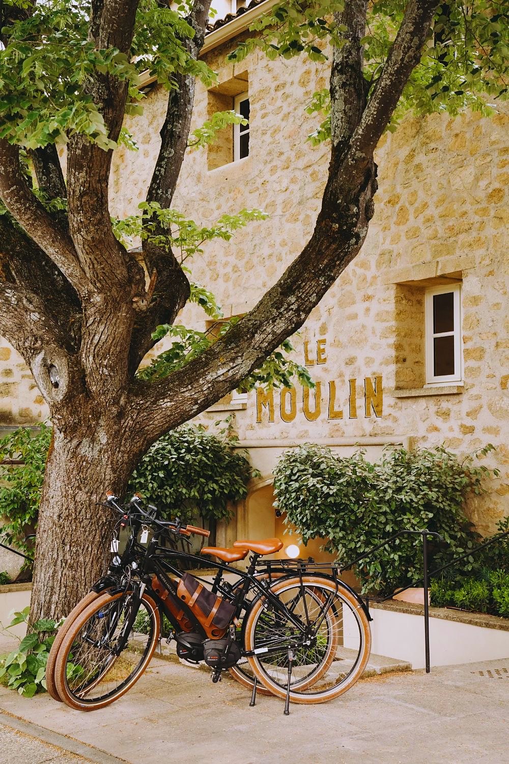 Electric bikes against a stone building in Provence